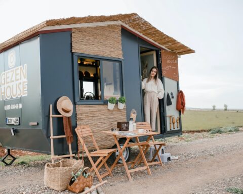 Woman Standing in a Trailer Converted to a House on Wheels