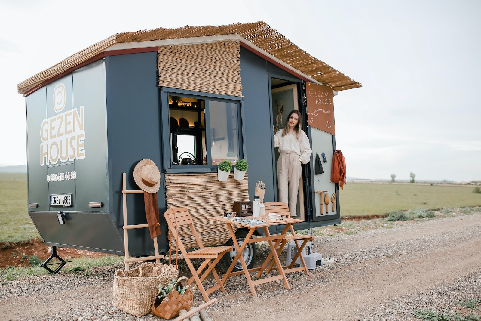 Woman Standing in a Trailer Converted to a House on Wheels